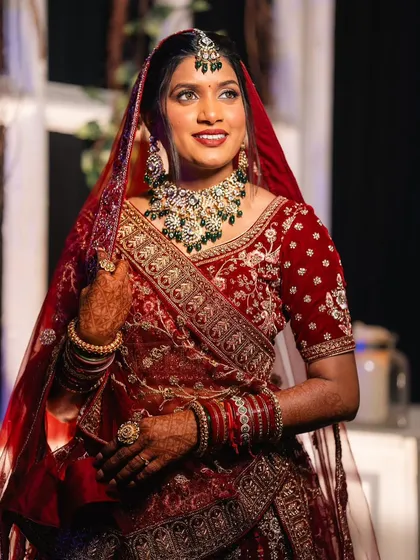 A full-length shot of the bride in her magnificent red lehenga, looking every bit the queen.
