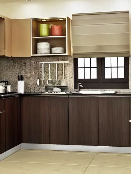 A classic L-shaped kitchen with a two-tone design of dark wood and beige cabinets. The mosaic tile backsplash and stainless steel accessories complete the look.
