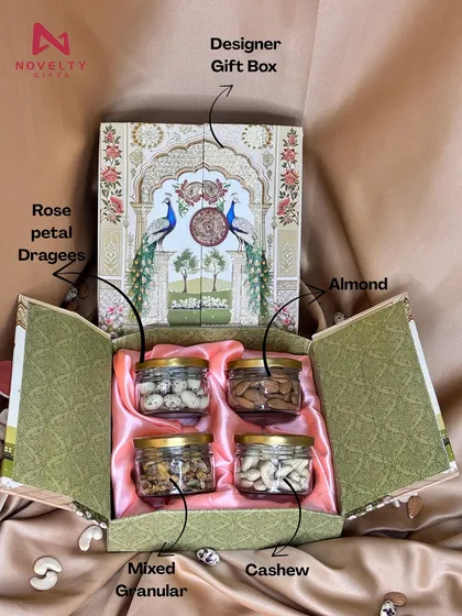 A classic choice for any occasion, this designer dry fruit hamper is always a winner. This particular box opens up to reveal four jars filled with premium almonds, cashews, rose petal dragees, and mixed granular nuts. The elegant peacock design makes it a festive favorite.