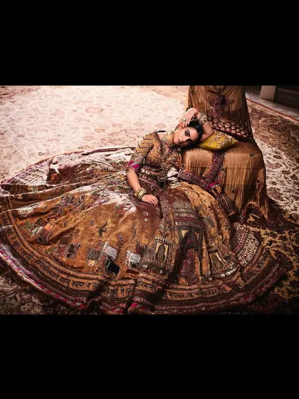 A dramatic, reclining pose that highlights the sheer volume and artistry of the vintage-inspired lehenga. This kind of editorial shot brings the outfit's story to life.