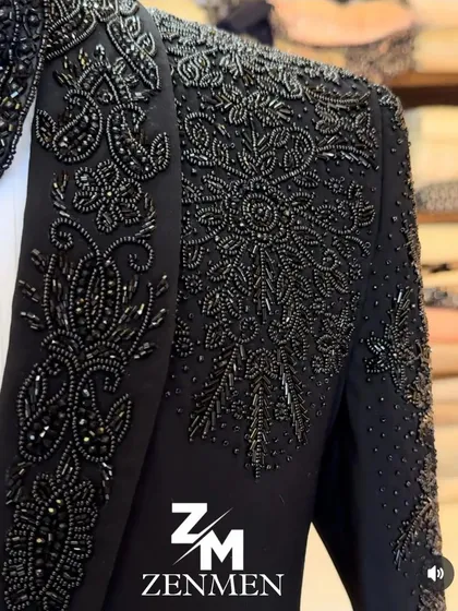 A close-up of a black tuxedo with incredibly dense and intricate black-on-black beadwork. This is a masterpiece of texture and subtle luxury.