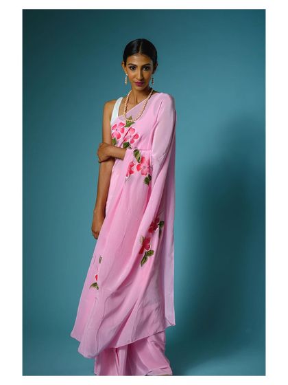This image showcases the pink saree from a different angle, highlighting the floral pattern along the border.