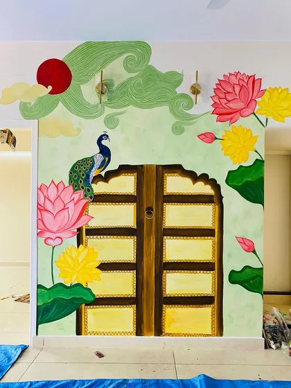 This traditional backdrop for a pooja mantap is one of our favorite projects. We worked closely with the client to bring together elements like the Jaipur-style door, vibrant Pichwai lotuses, and a proud peacock, creating a truly divine space.