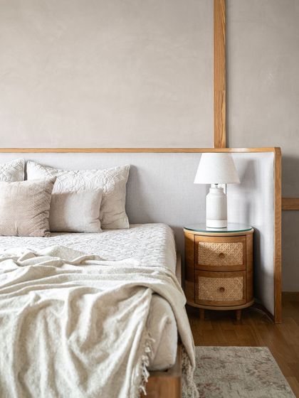 Another angle of the minimalist bedroom, showing the soft, layered neutral bedding that enhances the calm and cozy atmosphere.