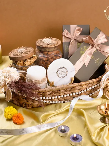 For Diwali, I love creating hampers that glow with warmth and tradition. This wicker basket arrangement combines artisanal candles, jars of premium nuts, and beautifully packaged sweets, all tied together with my custom ribbon to light up your festive celebrations.