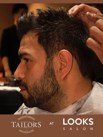 This client is receiving a signature cut and beard shaping. Notice the clean lines and even texture, a result of using professional tools and techniques to create a cohesive, well-groomed look.