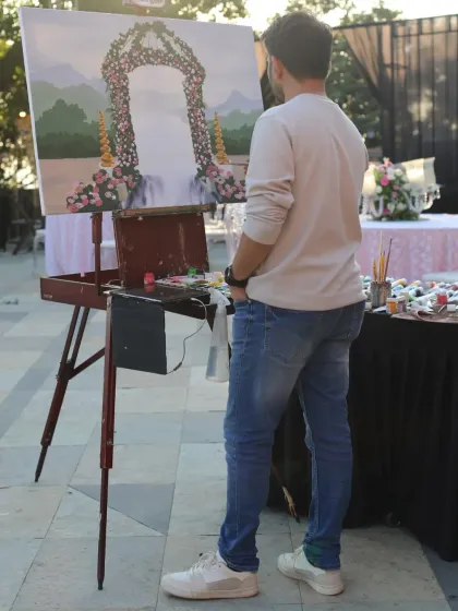 Vivek standing back to assess the composition of the painting. This is a crucial step to ensure the final piece is balanced and beautiful.