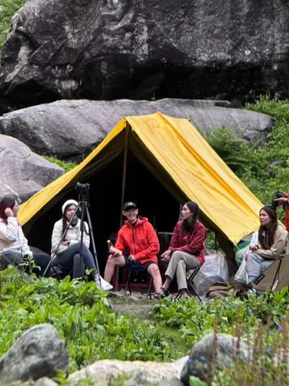 Chilling at the campsite. Our Thai trekkers enjoying a moment of rest and conversation amidst the rocks and greenery.