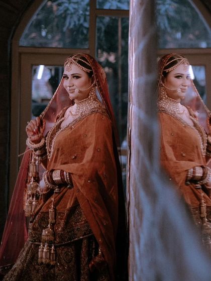 A creative portrait of Nisha, her reflection in a pillar adding a touch of glamour and mystery to the shot.