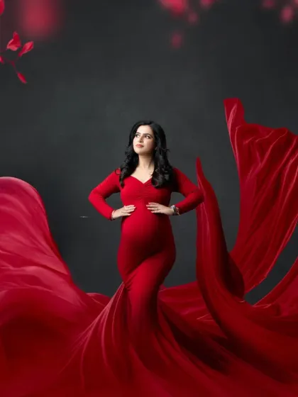 A regal pose celebrating the miracle of life. The rich red of the gown and the dramatic sweep of the fabric make for a truly breathtaking maternity photograph.