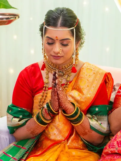 This bride is wearing the traditional 'mundavalya' across her forehead. Her makeup features subtle blush tones and defined eyes, perfectly suited for the solemnity and joy of the wedding rituals.