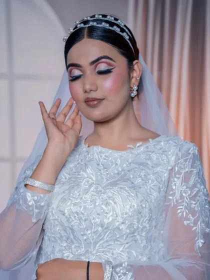 With eyes closed, you can see the delicate pink and white eyeshadow work, creating a soft and dreamy effect perfect for a church wedding.