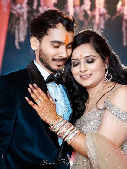 An intimate close-up of a newly engaged couple, highlighting the bride's henna and the tender moment they share.