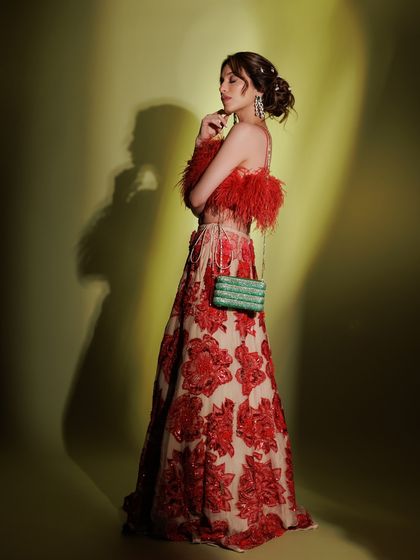 A full-length shot that captures the drama and elegance of the complete look. The makeup is kept soft and glowing to balance the vibrant, textured outfit.