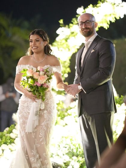 A beautiful moment from the ceremony. Her natural, glowing makeup looks perfect as she shares a smile, proving that the best bridal look is one that lets your happiness shine through.