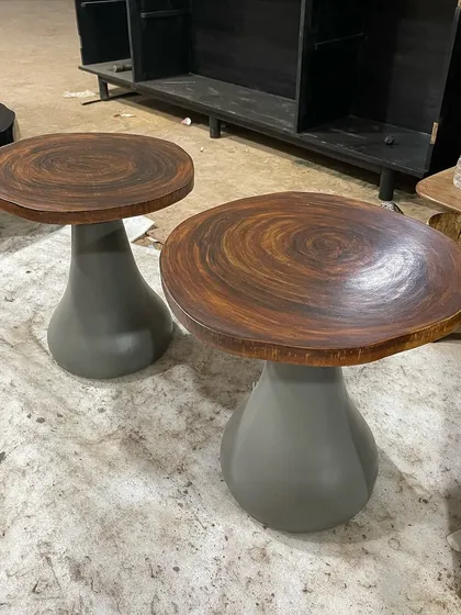 A pair of sculptural side tables with a unique two-tone finish, shown here on the workshop floor.