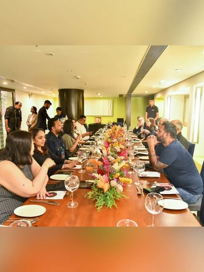 A view of the beautifully set long table for our Chef's Table Series. The floral arrangement and intimate setting create a perfect atmosphere for a unique dining experience.