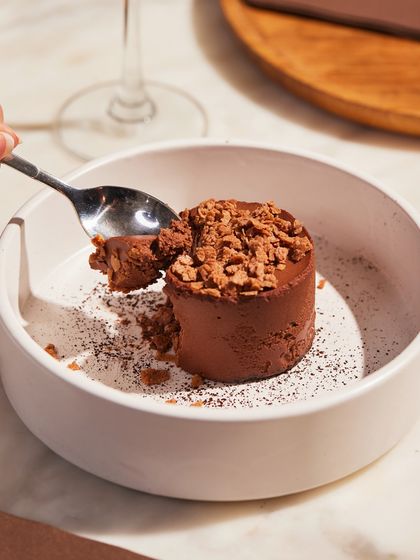 A spoonful of our decadent Bitter Chocolate Mousse. This dessert is consistently a favorite for private dinners and events, offering a sophisticated and satisfying sweet course.