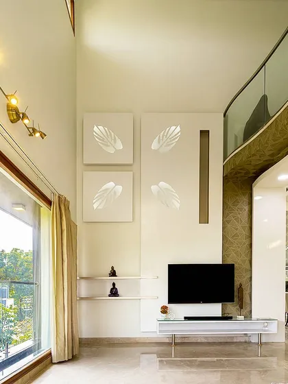 The living room of the 'Twin Abode' features a clean, minimalist aesthetic with a double-height ceiling and a large window that floods the space with light. The art on the wall adds a soft, angelic touch.