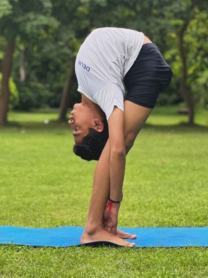 A deep standing forward fold, showcasing excellent spinal flexibility and hamstring length. We work on poses like this step by step to safely increase range of motion.