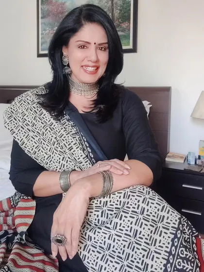 A relaxed, seated photo showcasing the complete ethnic look with a full set of silver jewellery.