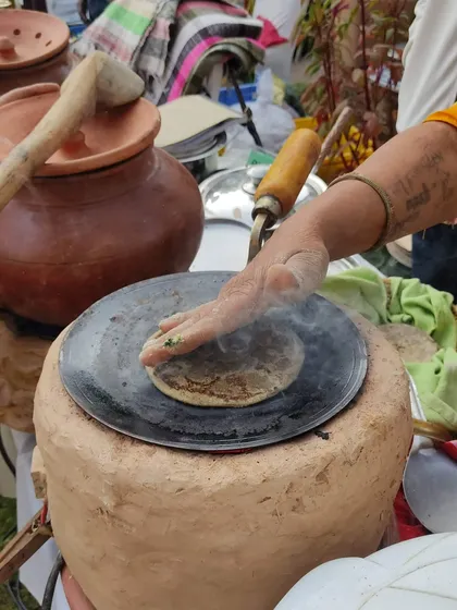 This is the real deal. Fresh bajre ki roti being made on a traditional clay chulha right at the market. We bring you authentic food experiences, connecting you to the taste and wisdom of our culinary traditions.