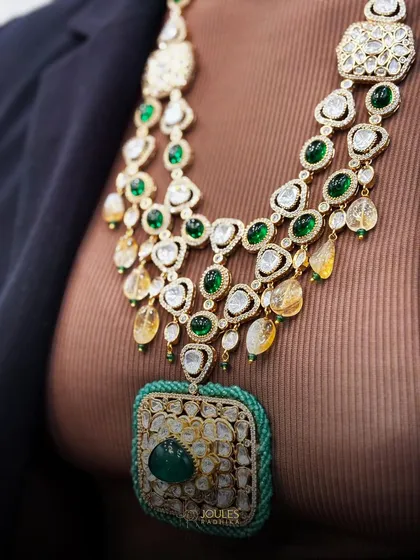 A close-up of the magnificent layered emerald set, showing the detail of the long necklace with its large square pendant and the complementary choker.
