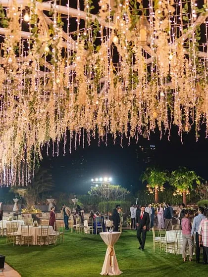 A magical reception under a massive ceiling of cascading white flowers and fairy lights, creating the feeling of a starry night.