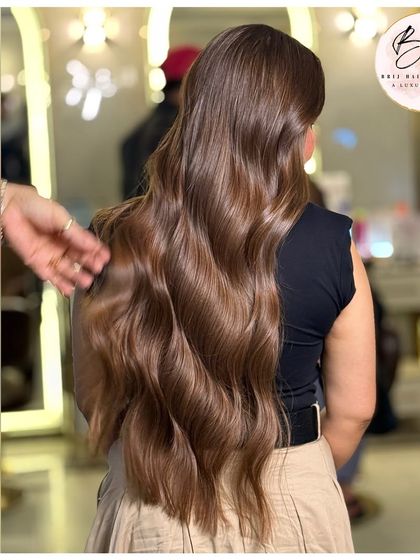 From the back, you can truly appreciate the seamless flow of this brunette balayage. The light catches the waves beautifully, showing off the different tones.
