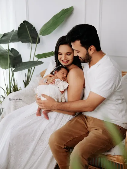 A candid-style family photo, capturing a quiet moment of admiration for their new baby. These natural interactions create the most authentic portraits.