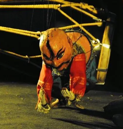 This is a character from one of our traditional puppet plays. The dramatic expression is hand-painted to be visible from afar, and the unique stringing allows for complex movements like bowing, which is essential for storytelling.