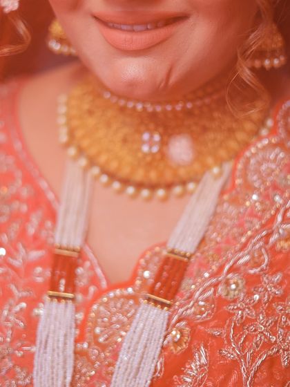 An abstract, artistic close-up focusing on the details of the bride's necklace and smile.