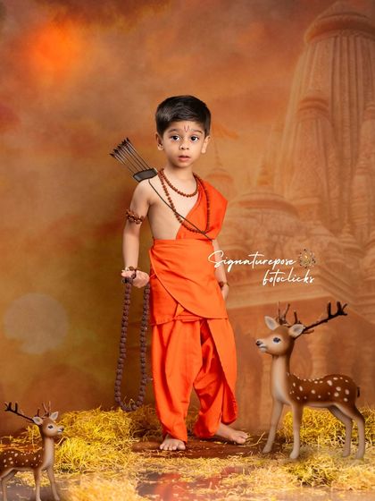 A full portrait of our young Rama, standing proudly with his deer companions against a warm, atmospheric background.