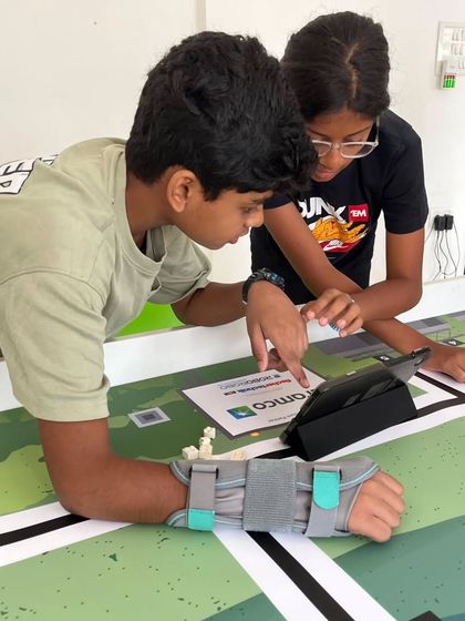 Teamwork in action as two students review instructions on a tablet while assembling game elements for the WRO. Even a student with a wrist brace is fully engaged, showcasing the dedication of our teams.