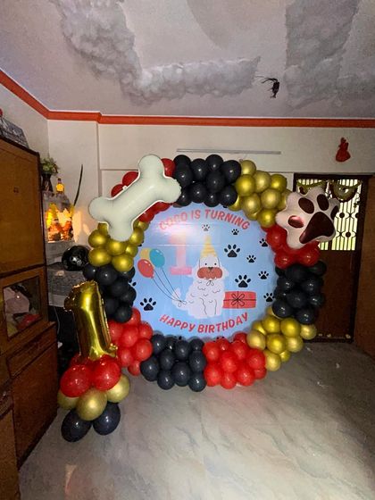 Even our furry friends deserve a celebration! This was a fun first birthday party for a beloved dog named Coco. The setup included a custom backdrop, a bone-shaped balloon, and a number '1' balloon column.