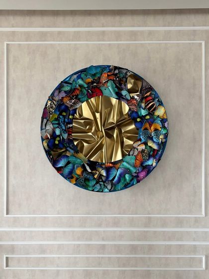 The circular butterfly sculpture serves as a powerful centerpiece in this elegant living room.