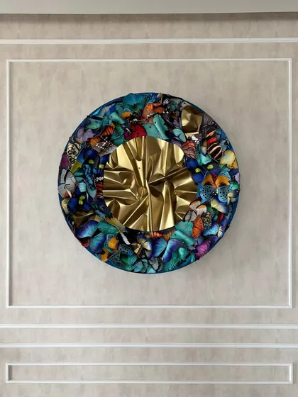 The circular butterfly sculpture serves as a powerful centerpiece in this elegant living room.
