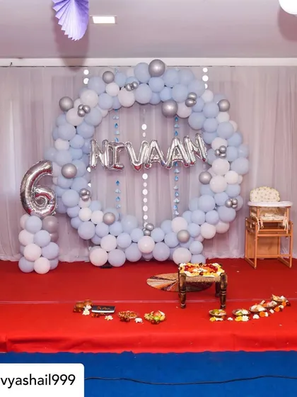 This setup was for Nivaan's Annaprashan, or first rice-eating ceremony. I created a gentle blue and silver theme with a circular balloon arch, a foil name banner, and a number '6' balloon to mark his six-month milestone.