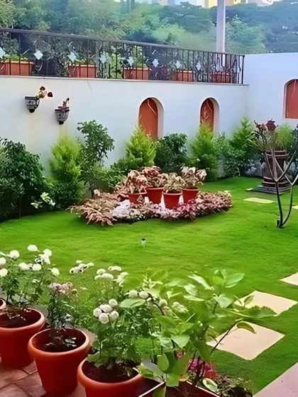 A stunning terrace garden with a manicured lawn, stone stepping-path, and a variety of potted plants and shrubs. We specialize in transforming rooftops and terraces into beautiful and functional gardens.