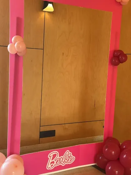 A life-sized Barbie photo booth frame. This is a perfect interactive element for a Barbie-themed party, allowing guests to take fun pictures.