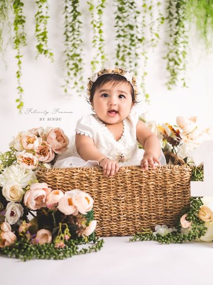 Halfway to one! This sitter session marks the six-month milestone with a beautiful floral basket setup, perfectly framing this adorable baby girl.