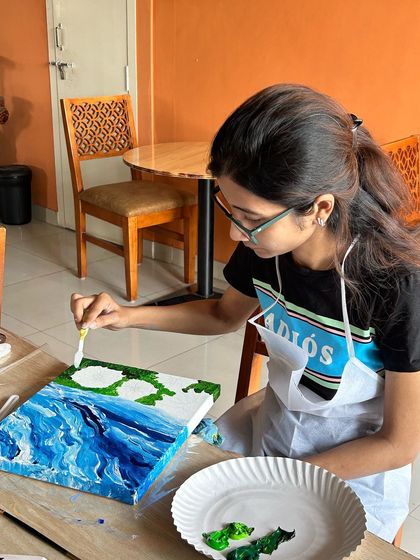 A participant carefully adding details to her sunflower painting. Our workshops are guided, but there's always room for personal creative touches.