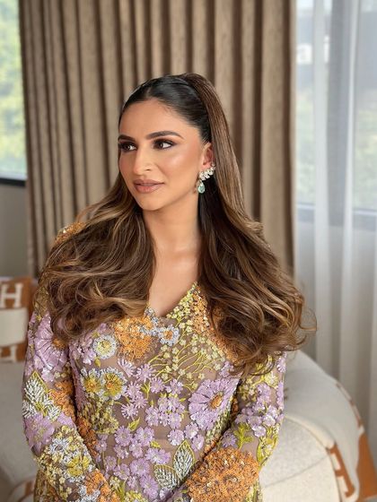 A chic and sleek half-ponytail with soft, voluminous waves. This is a modern and polished look, perfect for a stylish daytime event.