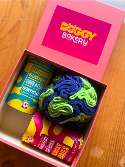 A bright and cheerful shot of our Doggy Delight Gift Box, showing the vibrant packaging of our handcrafted biscuits and culinary jerkies.