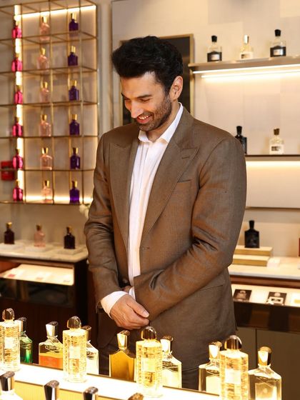 A candid moment of Aditya Roy Kapur, smiling while wearing our classic brown suit. It shows that true style is not just about looking good, but feeling good too.