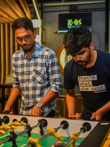 Two players locked in an intense game of foosball. The concentration is palpable.