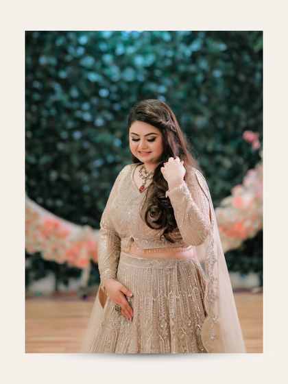 A serene portrait of the bride, Ishita. Her gentle, downward glance and the soft floral background create a moment of quiet beauty and contemplation.