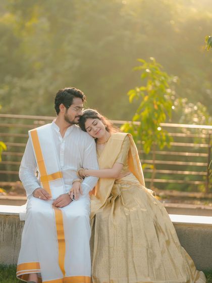 A tender moment between a couple in traditional South Indian attire, captured in soft, golden sunlight. This photo radiates warmth, peace, and affection.