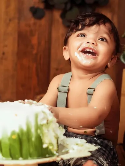Pure joy and a messy face. This is what a successful cake smash looks like. The rustic decor adds a warm, timeless feel to the celebration.