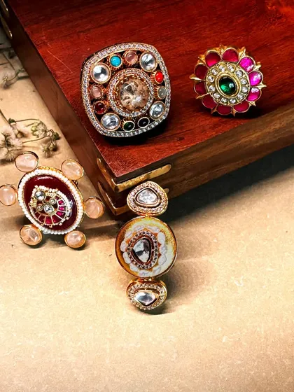 A beautiful arrangement of our statement rings, including a navratna design, a ruby floral ring, and other unique polki pieces.